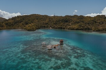 Sticker - Amazing Aerial Shot of a Luxurious Cottage in the Middle of the Blue Ocean Water