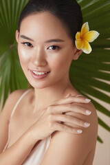 Wall Mural - beauty. model near palm with flower in hair. tender asian woman touching shoulder portrait on tropic