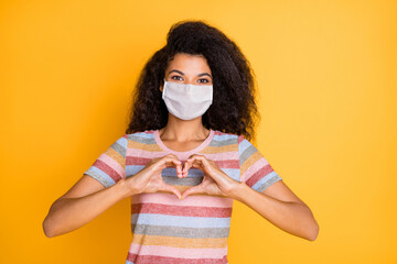 Wall Mural - Close-up portrait of her she nice healthy wavy-haired girl wearing safety mask showing heart shape influenza grippe contamination isolated bright vivid shine vibrant yellow color background