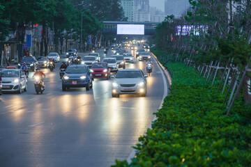 Hanoi traffic with modern buildings on Nguyen Chi Thanh street at twilight