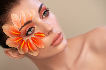 Wall Mural - portrait of beautiful young woman with makeup petals. brunette woman with luxury makeup. perfect ski
