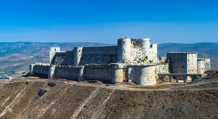 It's Krak des Chevaliers, also Crac des Chevaliers, is a Crusader castle in Syria and one of the most important preserved medieval castles in the world.