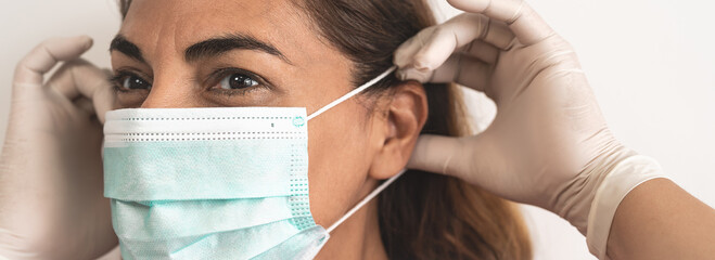 Mature Latin woman wearing face surgical mask and gloves - People preventing against corona virus spread - Healthcare and medical protection concept