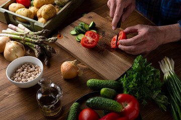 Canvas Print - Men in the kitchen preparing salad, vegan food