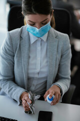 Beautiful businesswoman with medical mask working in office. Young businesswoman working on lap top.	