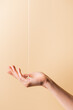 cropped view of female hand under flowing liquid soap isolated on beige