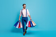 © deagreez - Full body photo of handsome business man worker carry many bags buy clothes vacation shopping center wear specs shirt suspenders pants boots socks isolated pastel blue color background