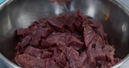 Wall Mural - Chef putting sliced raw beef meat into bowl at kitchen