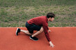 © LIGHTFIELD STUDIOS - Side view of sportsman in starting position on running track while working out in park