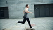 © stockbusters - Fitness man running on urban street in slow motion. Male runner jogging outdoor.