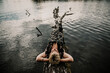 Europe, Germany, Berlin, Mueggelheim, Grosse Krampe, woman relaxing on a tree in the lake.