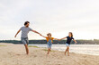© pikselstock - Father with two children enjoying a day at the beach