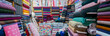 © AMAR - clothes in shop, Rolls of fabric and textiles for sale stacked on shelves in shop, View of cloth rolls of different colors and patterns on shelves in fabric store