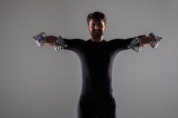 Wall Mural - Young fit man on bench with a bar weights in hands training, isolated on white background. Fitness exercises with dumbbells concept.