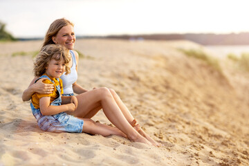 Wall Mural - Mother and a child enjoying a day at the beach
