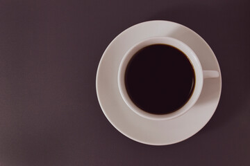 Cup of black coffee on dark surface, top view