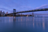 Fototapeta Nowy Jork - View on Dumbo location from East River with long exposure at dawn