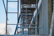 © yarohork - Empty scaffolding near the building with spread out work items - ropes, buckets, uniforms and a ladder