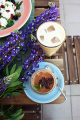 Sticker - Coffee and tiramisu on the table on the veranda of the coffee shop