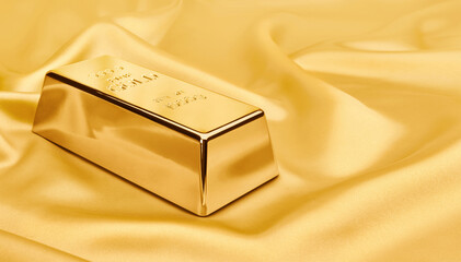 Gold bar on satin fabric. financial concept.