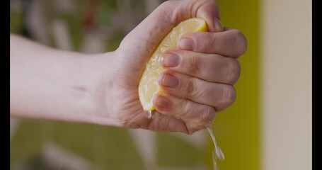 Sticker - Female hand squeezing fresh lemon half, making juice