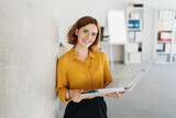 Fototapeta Panele - Attractive young office worker holding large file