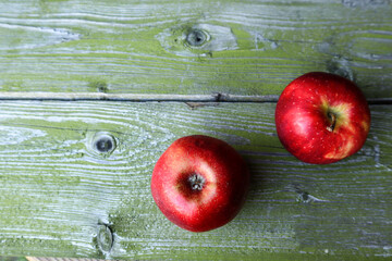 Two red apples on a wooden background, close-up, top view, place for the inscription-healthy food concept