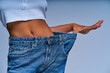 © IC Production - Girl in jeans several sizes larger than she wears shows her belly. Diet concept