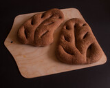 Fototapeta  - Domowe bochenki chleba w kształcie liścia umieszczone na drewnianej desce
