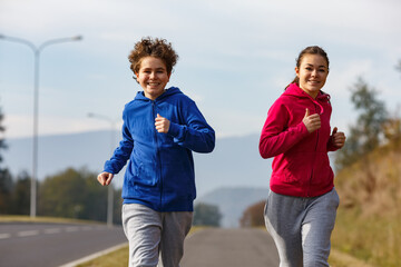 Wall Mural - Girl and boy running, jumping outdoor
