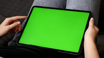 Female relaxes at home with big green screen display tablet 4K footage