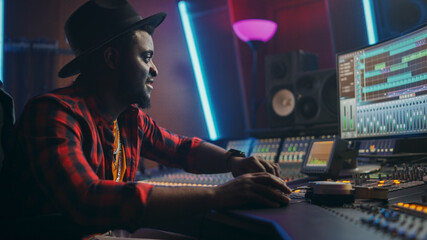 Poster - Stylish Male Audio Engineer Working in Music Recording Studio, Uses Mixing Board, Software to Create Modern Hit Song. Creative Artist Musician Working on Workdesk Control Surface to Produce New Song
