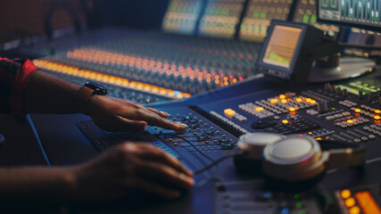 Fototapete - Music Creator, Musician, Artist Works in the Music Record Studio, Uses Surface Control Desk Equalizer Mixer. Buttons, Faders, Sliders to Broadcast, Record, Play Hit Song. Close-up Focus on Hands