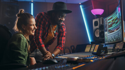 Fototapete - Stylish Producer and Audio Engineer Working together in Music Recording Studio on New Album, Talk, Use Control Desk Equalizer, Mixing Board and Software to Create Hit Song. Artist and Musician Collab