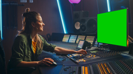 Fototapete - Portrait of Stylish Female Audio Engineer / Producer Working in Music Record Studio, Uses Green Screen Computer Display, Mixer Board, Control Desk to Create New Song. Creative Artist Musician 