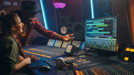 Fototapete - Producer and Professional Audio Engineer Working together in Music Recording Studio on a New Album, Talk, Use Control Desk Equalizer, Mixing Board and Software to Create Hit Song. Artist and Musician