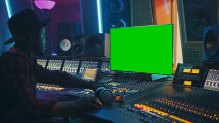 Poster - Stylish Audio Producer Working in Music Record Studio, Uses Green Screen Chroma key Computer Display, Mixer Board Equalizer and Control Desk to Create New Hit Song. Creative Black Artist Musician