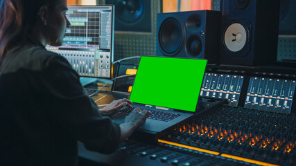 Poster - Female Artist, Musician, Producer, Audio Engineer Working in Music Record Studio on a New Album, Use Green Screen Laptop Computer, Control Desk for Mixing and Creating Hit Song. Over Shoulder