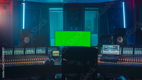 Modern Music Record Studio Control Desk with Green Screen Chroma Key Computer, Equalizer, Mixer and other Professional Equipment. Switchers, Buttons, Faders, Sliders. Record, Play Songs.