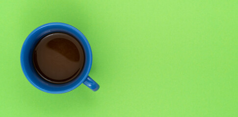 Top view, flat lay of black coffee cup on background green.