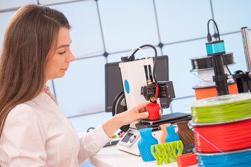 Sticker - Young female designer working on a prototype device on a 3D printer