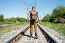 Traveler With A Backpack Is Walking On Empty Railway Road.