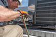 © spatesphoto - HVAC technician soldering copper line to condensing unit