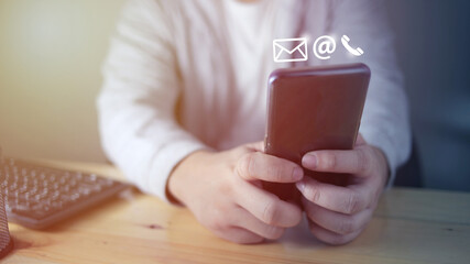 Contact us concept, man using smart phone with e-mail, mail, and phone icons graphic