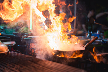 Chef is stirring vegetables in wok,Wok cooking a traditional stir fry. Street food in China, South-East Asia.