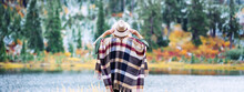 Adventure Woman Among Mountains, Enjoy The Wild. Forest And Lake Wearing Hat And Poncho, Boho And Wanderlust Style. Wide Screen, Panoramic