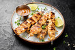 Grilled chicken satay skewers with peanut butter sauce.