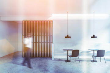 Man walking in white restaurant with bench