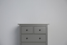 Grey Chest Of Drawers On Light Background. Space For Text