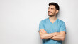 © Damir Khabirov - Banner of inspired man in blue t-shirt with crossed arms isolated on gray background